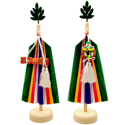 A pair of small wooden poles with small sakaki attached to the tip. Both bear streamers of green, yellow, red, white, and blue. A red and gold cloth case containing a miniature sword dangles on the left masakaki from a white string. A red and gold cloth case containing a mirror with green, yellow, and white dangles on the right masakaki from a white string. Both items have large white tassels.