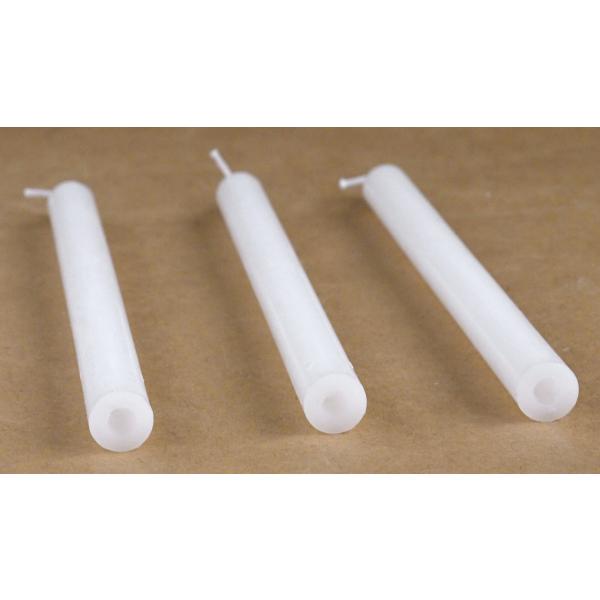 Three white candles with holes in the bottom.